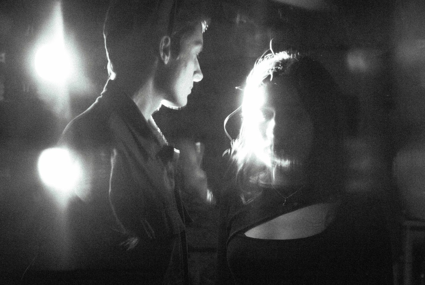 A blurry black and white image of a man & woman in black